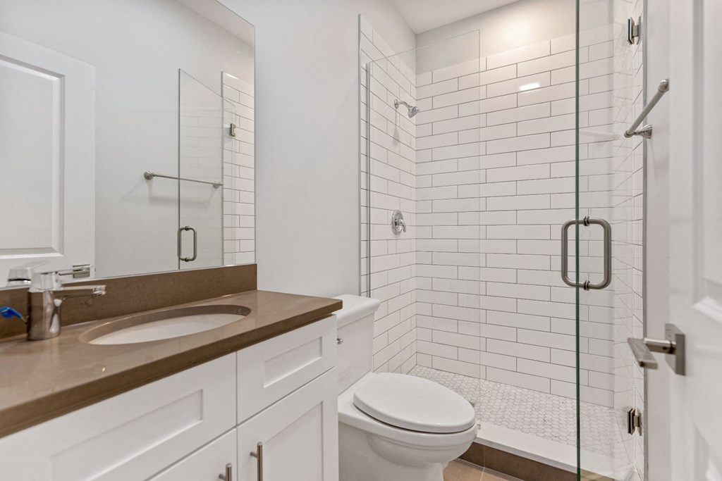 a white bathroom with a shower toilet and sink