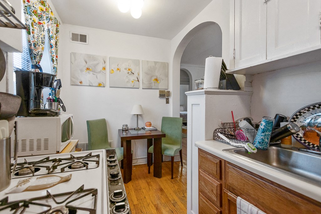 a kitchen with a stove and a sink and a dining room