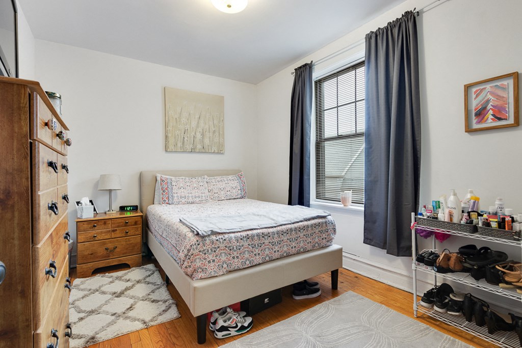a bedroom with a bed and a dresser and a window