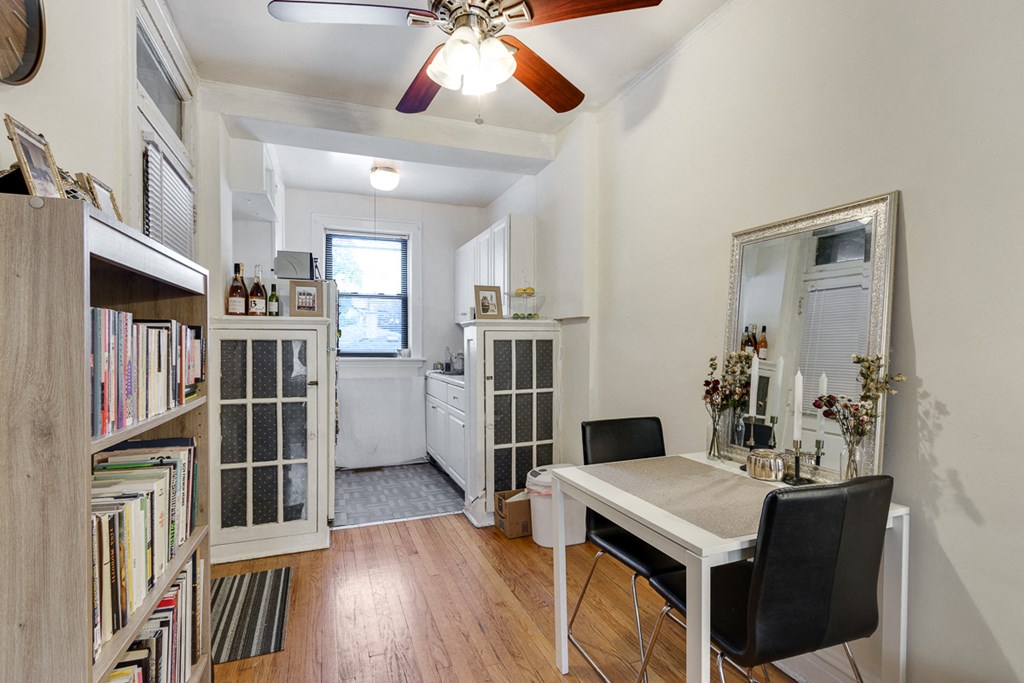 a dining room with a white table and a ceiling fan