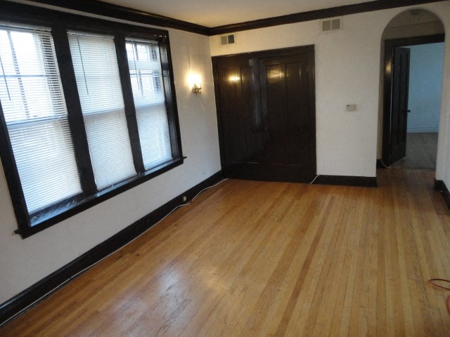 an empty living room with wood floors and windows