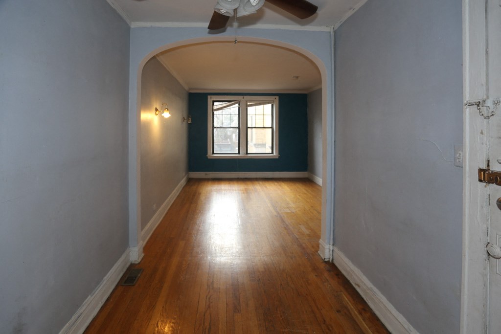 an empty room with a ceiling fan and a window
