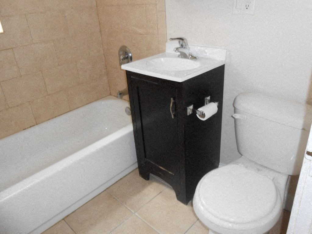 a bathroom with a toilet and a sink and a tub