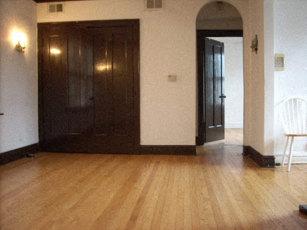 a living room with a wooden floor and two doors