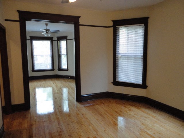 an empty living room with a hard wood floor and windows