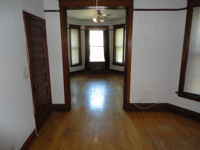 an empty living room with wood floors and windows