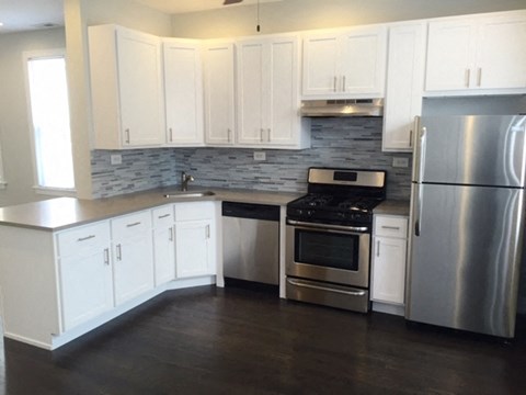 a kitchen with white cabinets and stainless steel appliances
