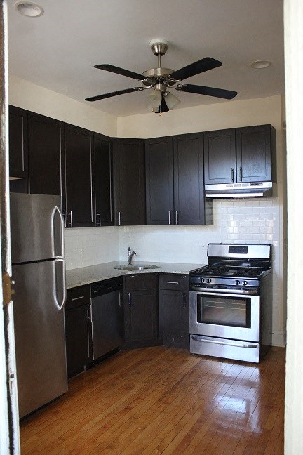 a kitchen with stainless steel appliances and a ceiling fan