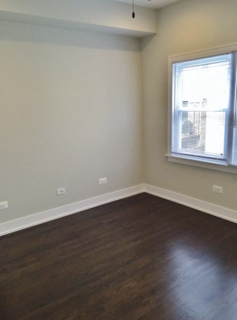 an empty room with wooden floors and a window