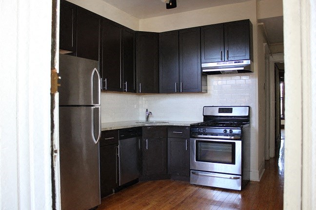 a kitchen with black cabinets and stainless steel appliances