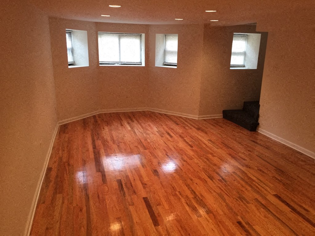 an empty living room with a hard wood floor