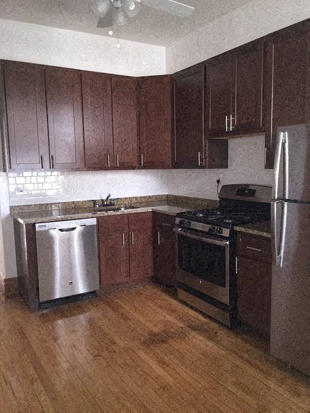 a kitchen with wooden cabinets and stainless steel appliances