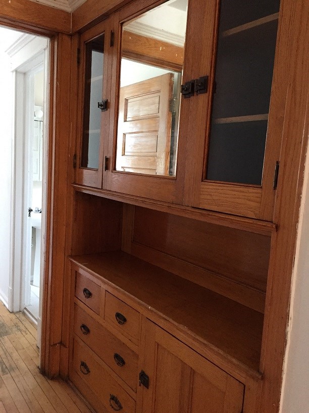a wooden cabinet with a mirror and drawers in it