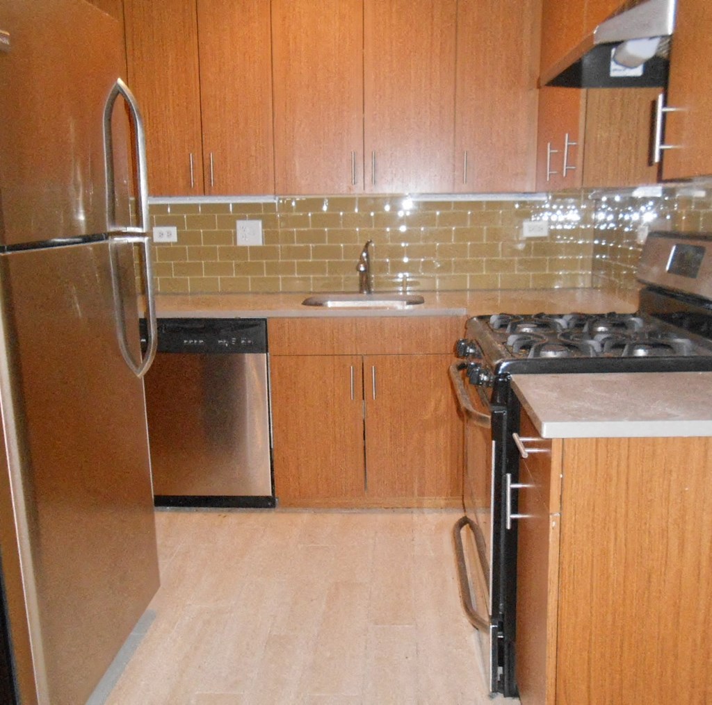 a kitchen with wooden cabinets and a stove and a refrigerator