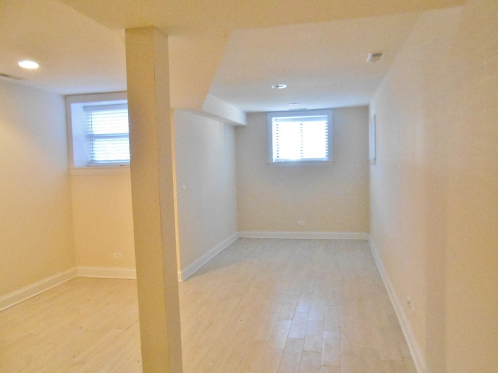 an empty room with wooden floors and a window
