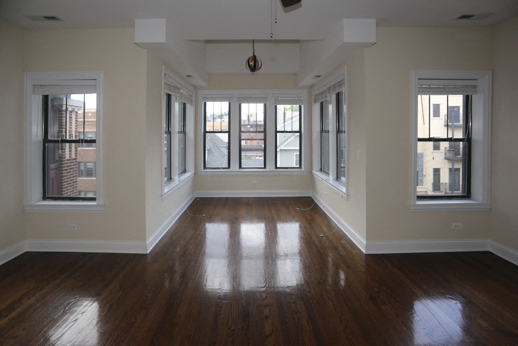 an empty living room with wood floors and windows