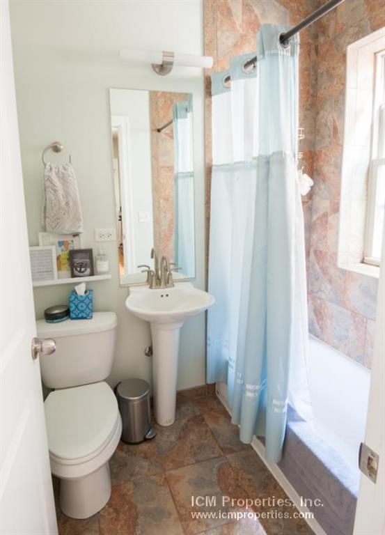 a bathroom with a toilet and a sink and a shower