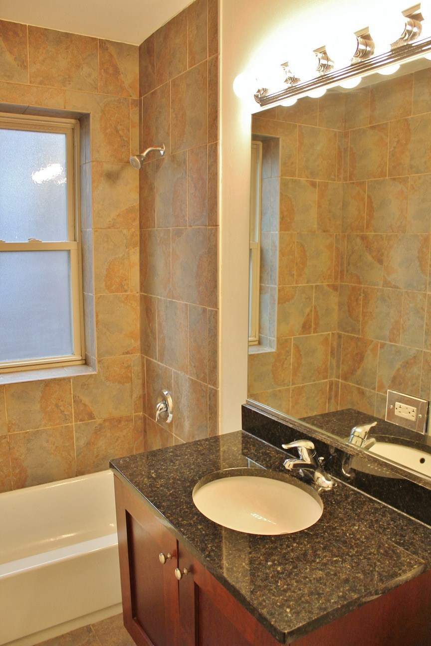 a bathroom with a sink and a shower and a mirror