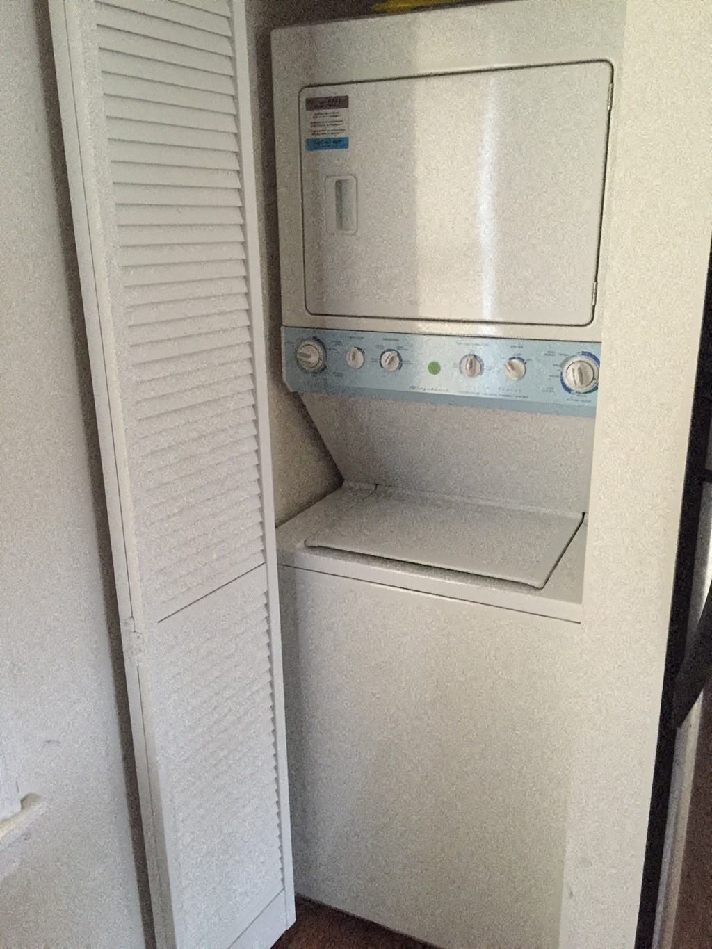 an empty refrigerator in a room with a door