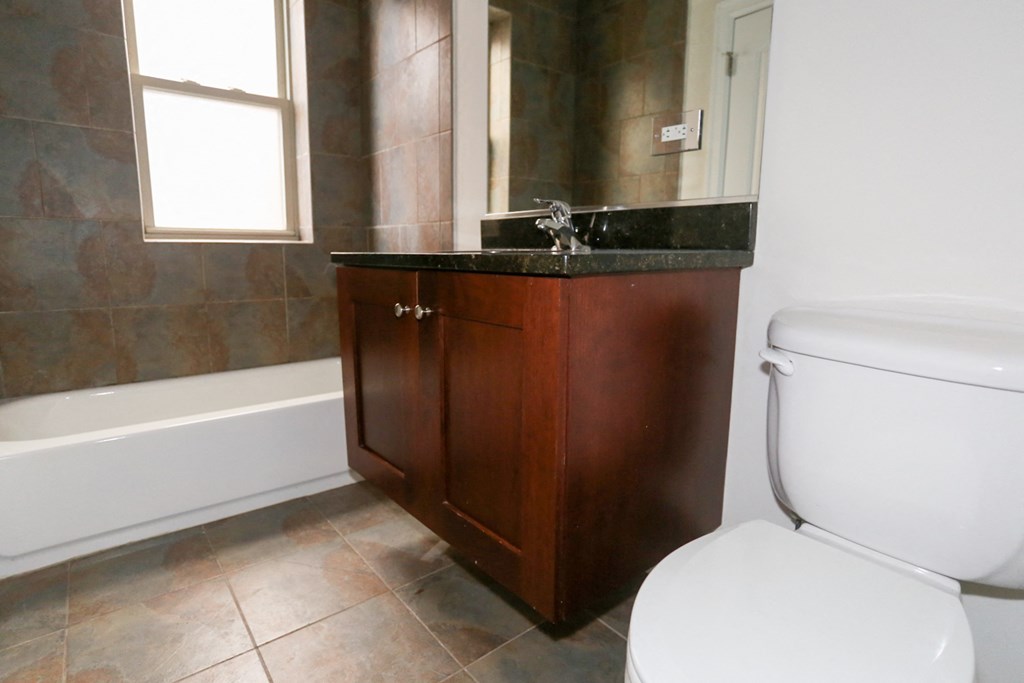 a bathroom with a toilet and a sink and a bath tub