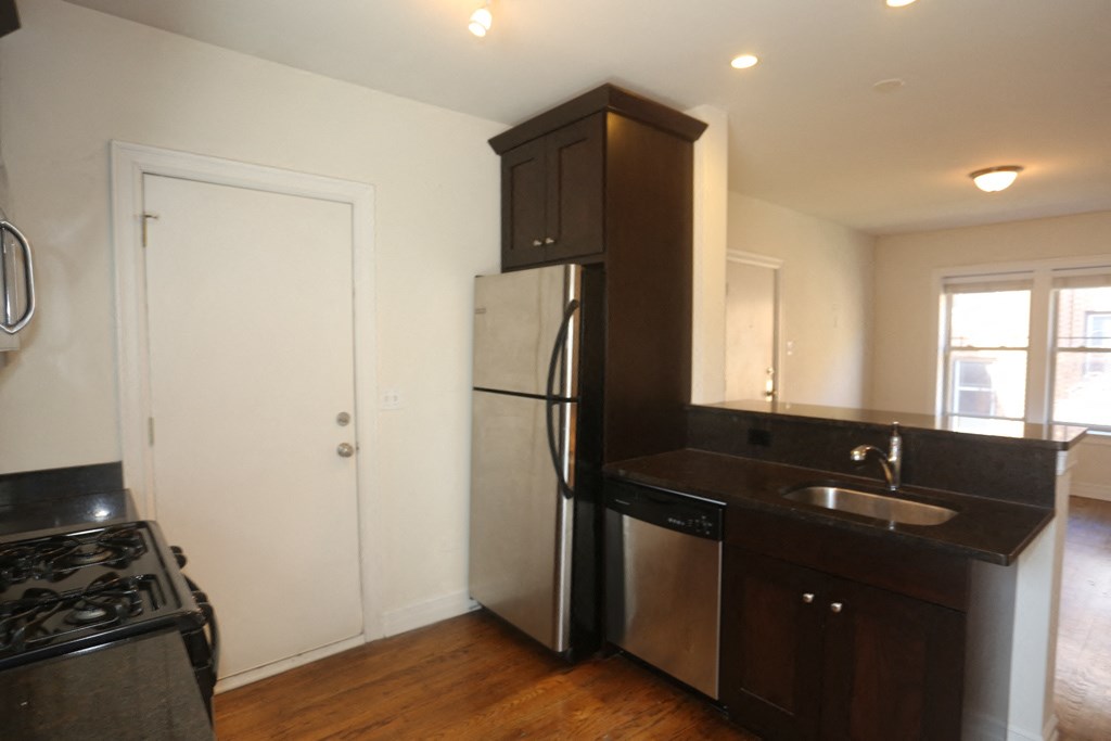 a kitchen with a stainless steel refrigerator and a sink