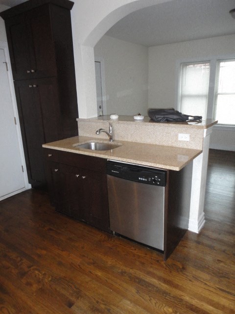 an empty kitchen with a sink and a dishwasher