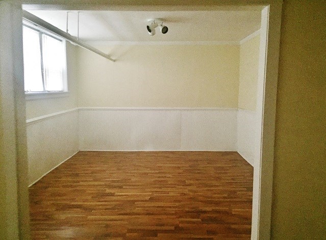 an empty room with a wood floor and a window