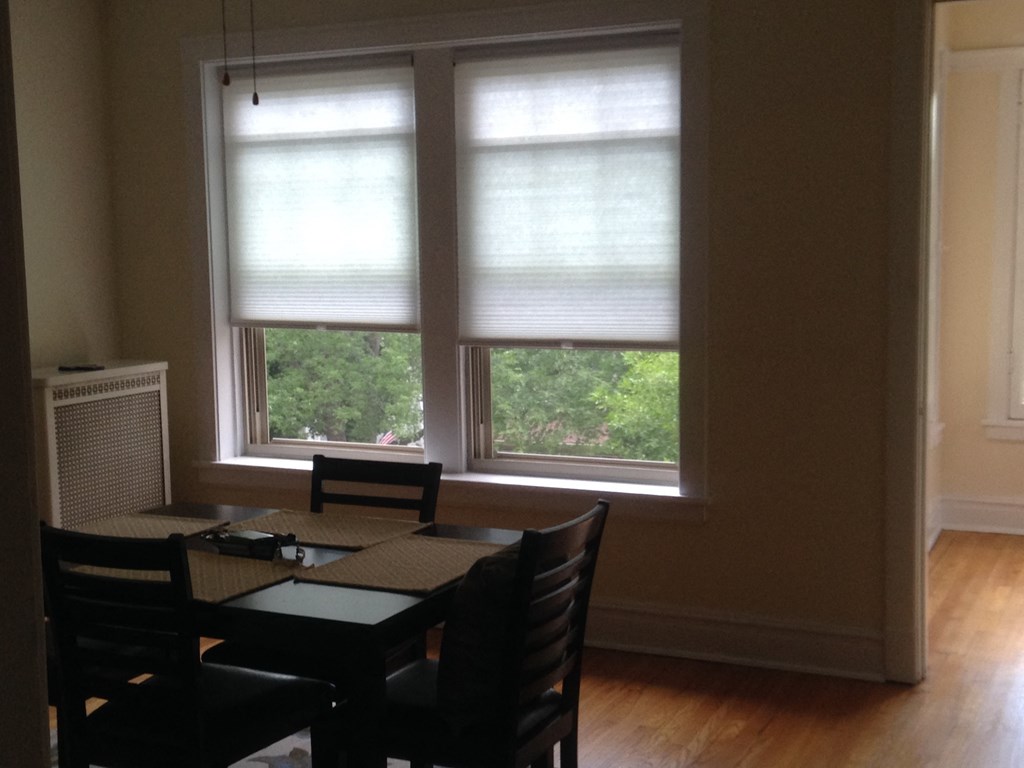 a dining room with three windows and a table with chairs