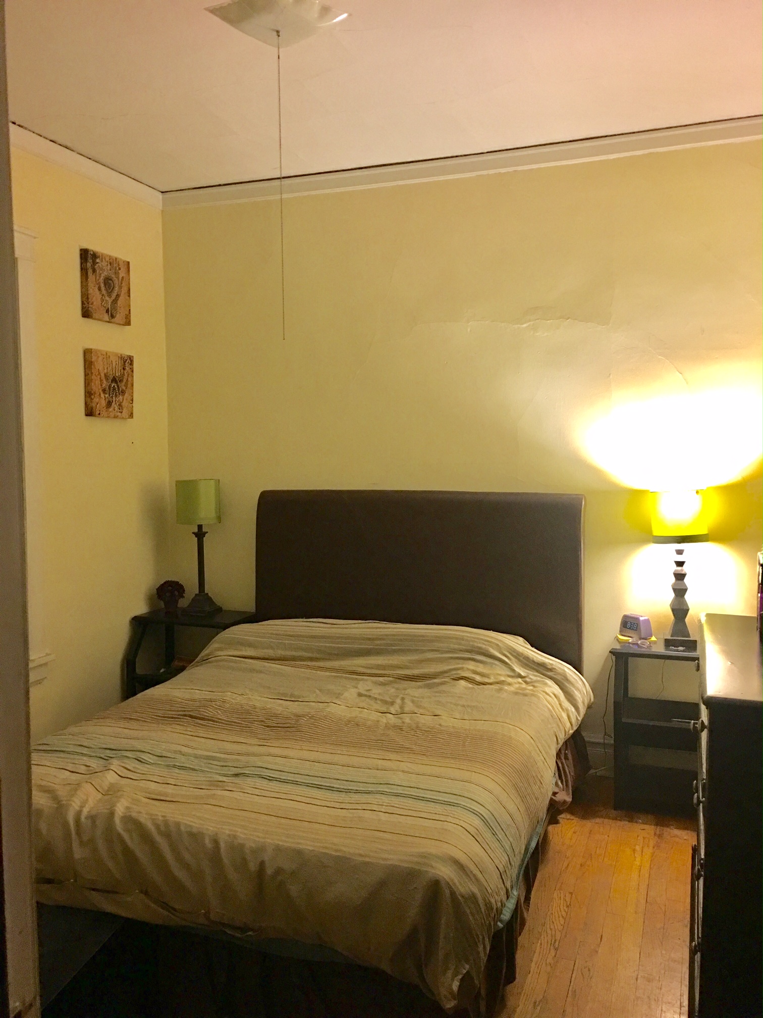 a bedroom with a bed and a nightstand with a lamp