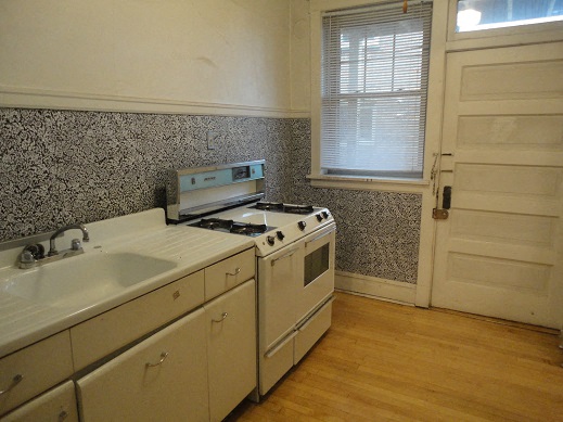 a kitchen with a stove and sink and a window
