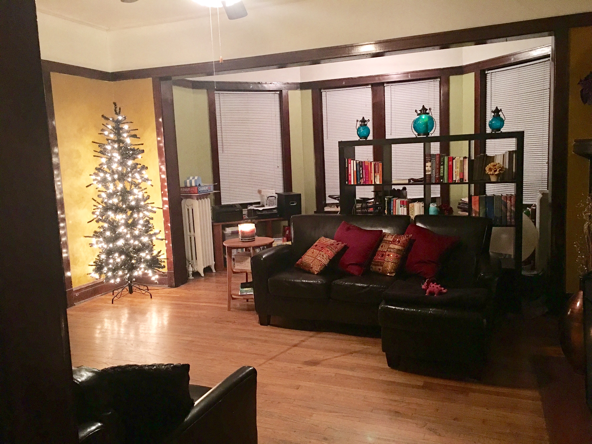 a living room with a christmas tree and a leather couch
