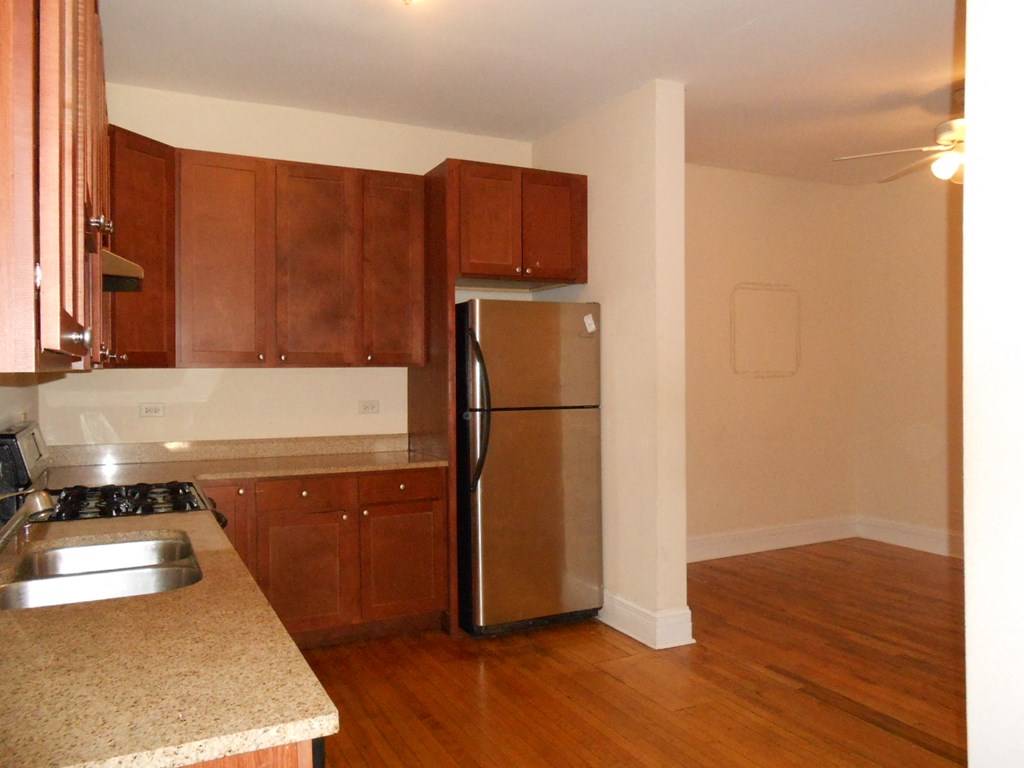 an empty kitchen with a stainless steel refrigerator