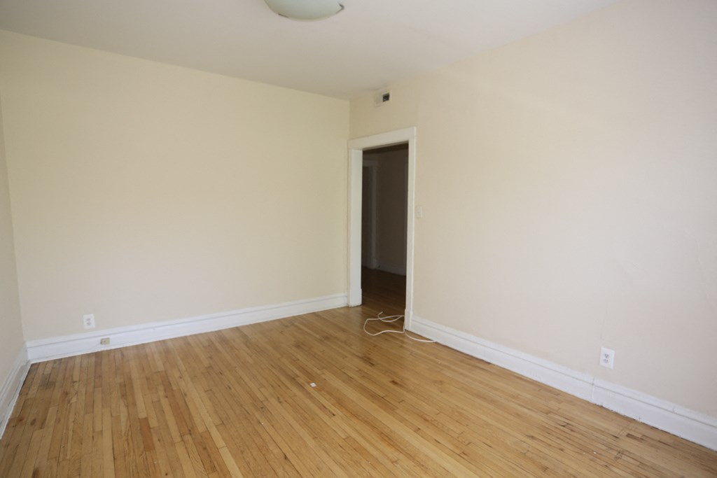 an empty room with white walls and a wooden floor