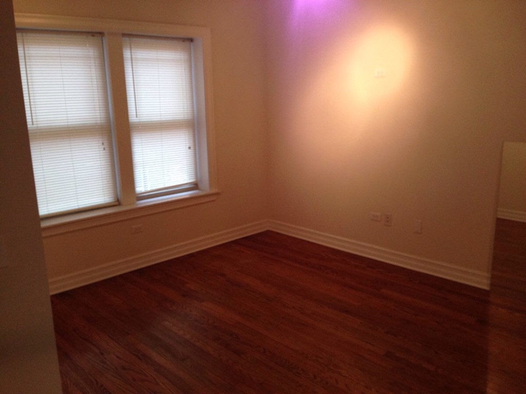 the living room with wood floors and two windows
