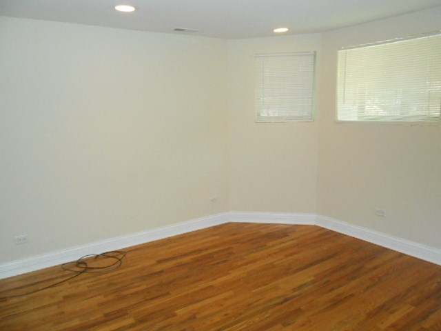 an empty room with wooden floors and white walls