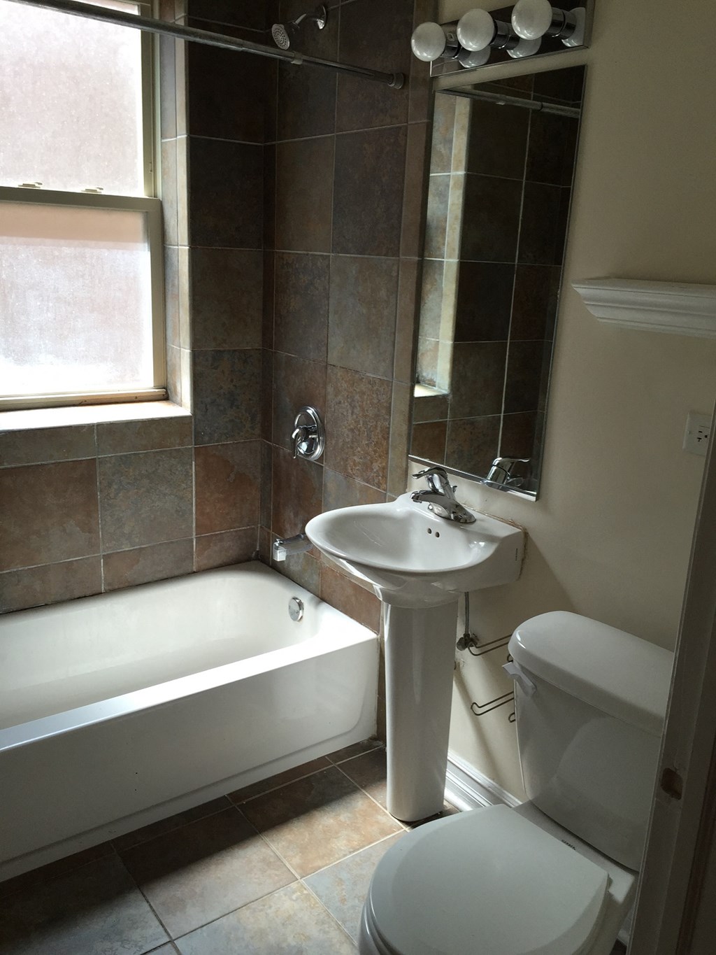 a small bathroom with a sink toilet and bath tub