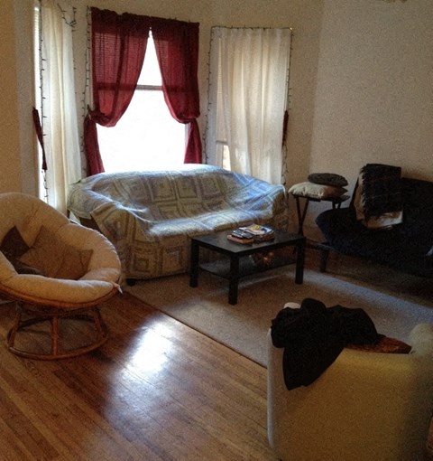 a living room with a bed and chairs in it