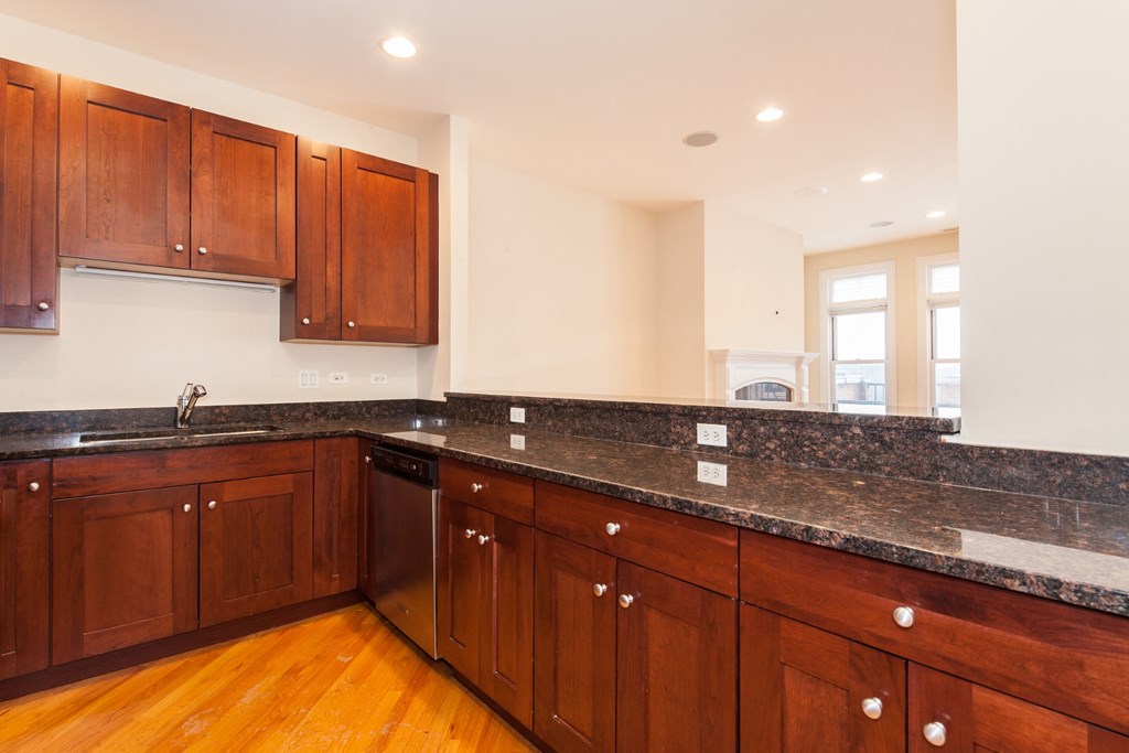 a kitchen with granite counter tops and wooden cabinets