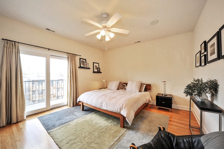 a bedroom with a large bed and a ceiling fan