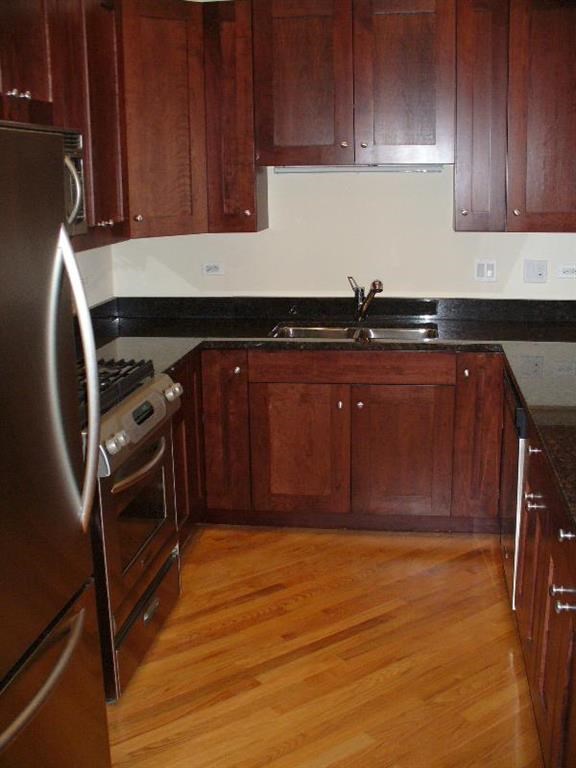 a kitchen with wooden cabinets and stainless steel appliances