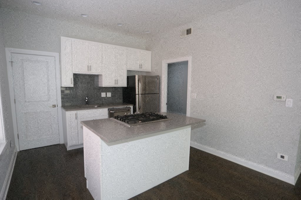 an empty kitchen with white cabinets and a counter top