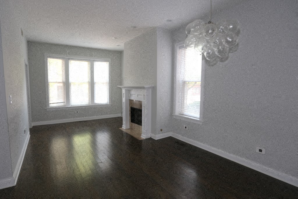 a empty room with a fireplace and a chandelier