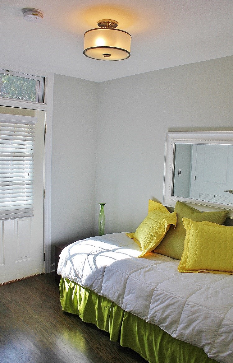 a bedroom with a bed with yellow pillows and a window