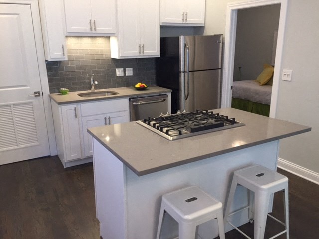a kitchen with a stove and a counter with three stools