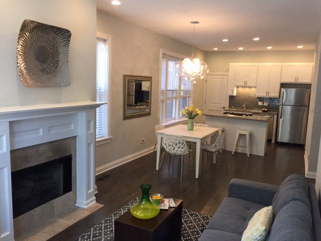 a living room with a fireplace and a table with chairs