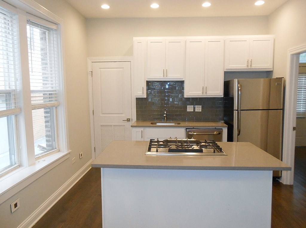 a kitchen with white cabinets and a stove and a refrigerator