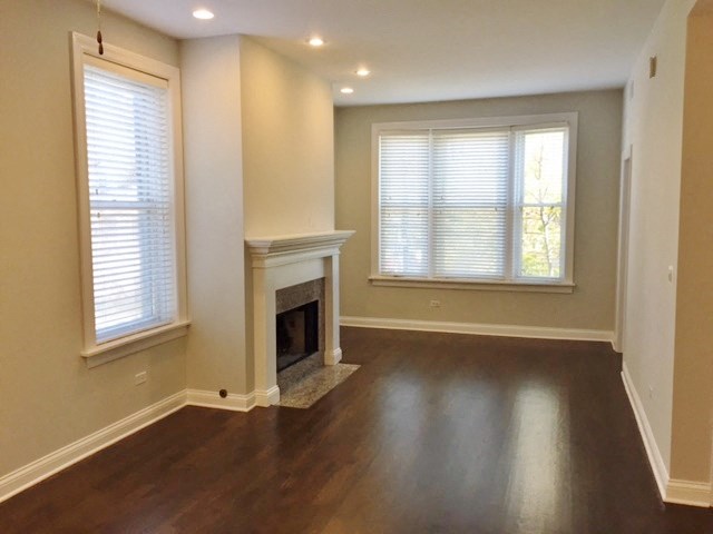 a living room with a fireplace and wooden floors