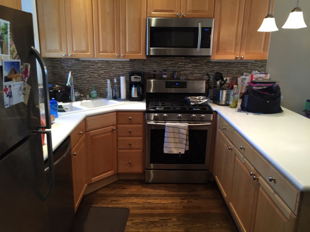 a kitchen with wooden cabinets and stainless steel appliances