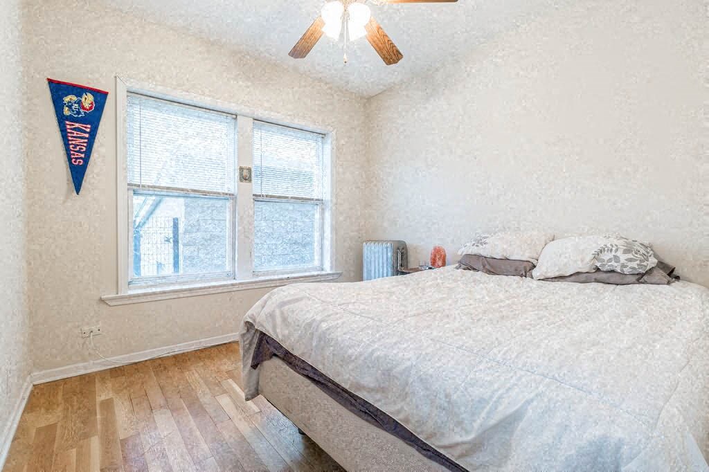 a bedroom with a bed and two windows