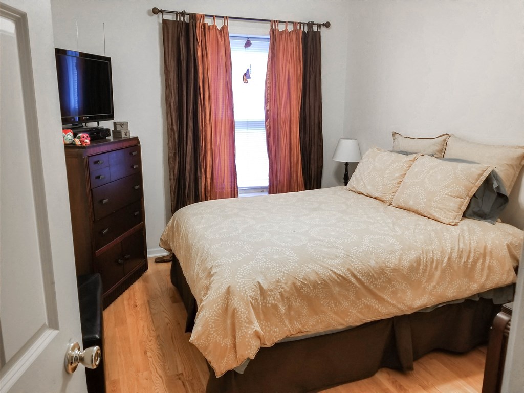 a bedroom with a bed and a dresser and a window
